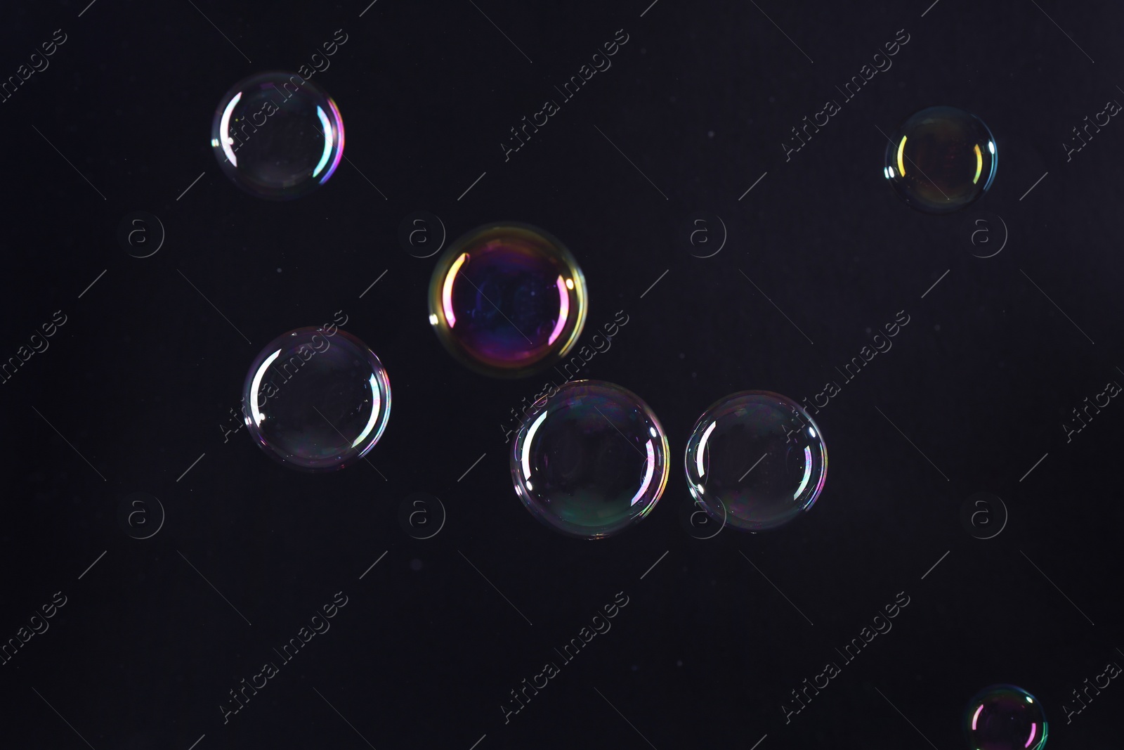 Photo of Beautiful transparent soap bubbles on dark background