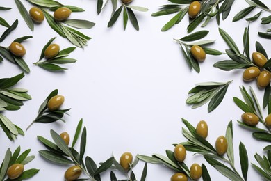Frame made of twigs with olives and fresh green leaves on white background, flat lay. Space for text