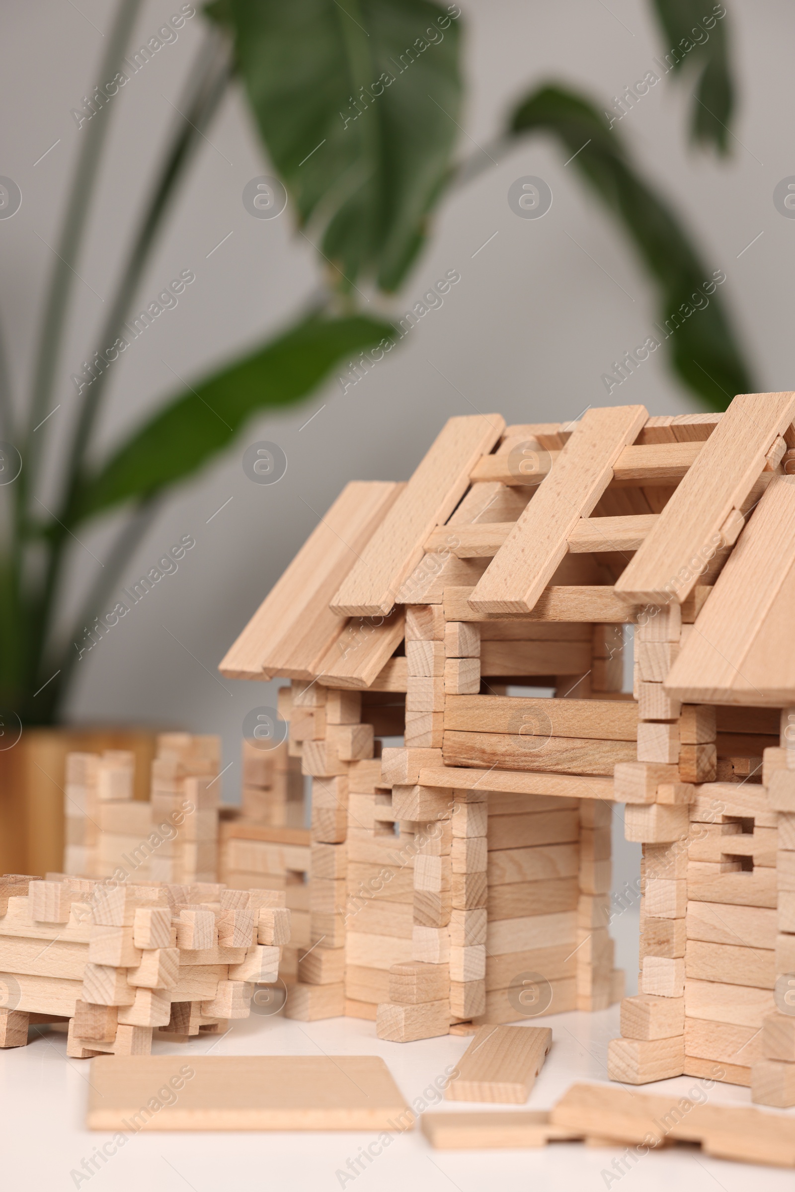 Photo of Wooden entry gate on white table against blurred background. Children's toy