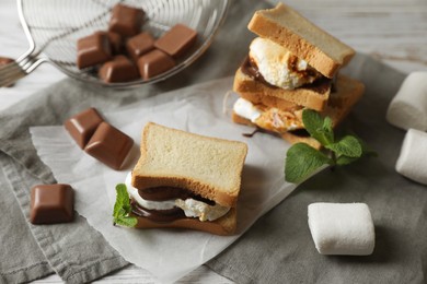 Photo of Delicious marshmallow sandwich with bread and chocolate on white wooden table, closeup
