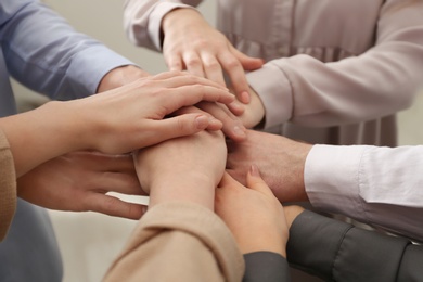 Photo of Group of people holding their hands together, closeup