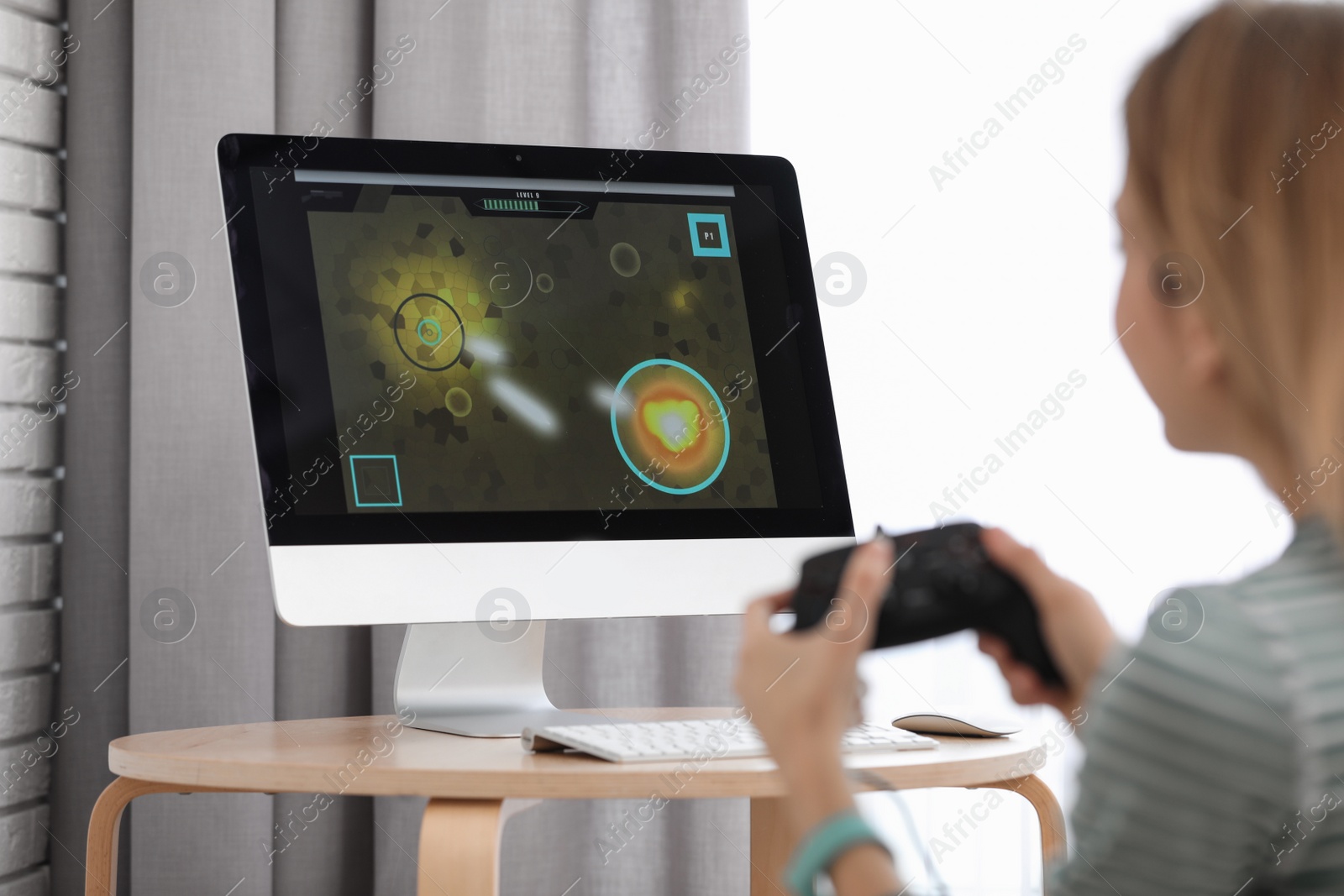 Photo of Young woman playing video game at home, closeup