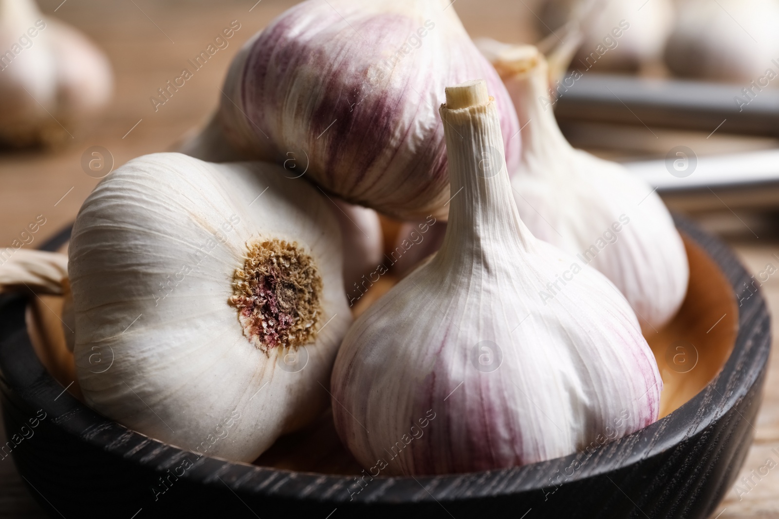 Photo of Fresh garlic in bowl, closeup. Organic product