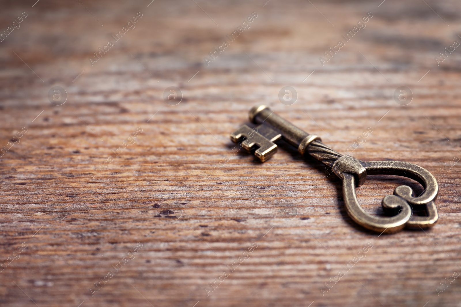 Photo of Old vintage key on wooden background, space for text