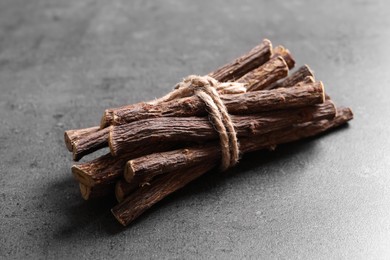Photo of Dried sticks of liquorice root on grey table, closeup