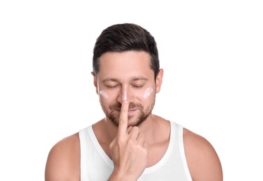 Man applying sun protection cream onto his face against white background