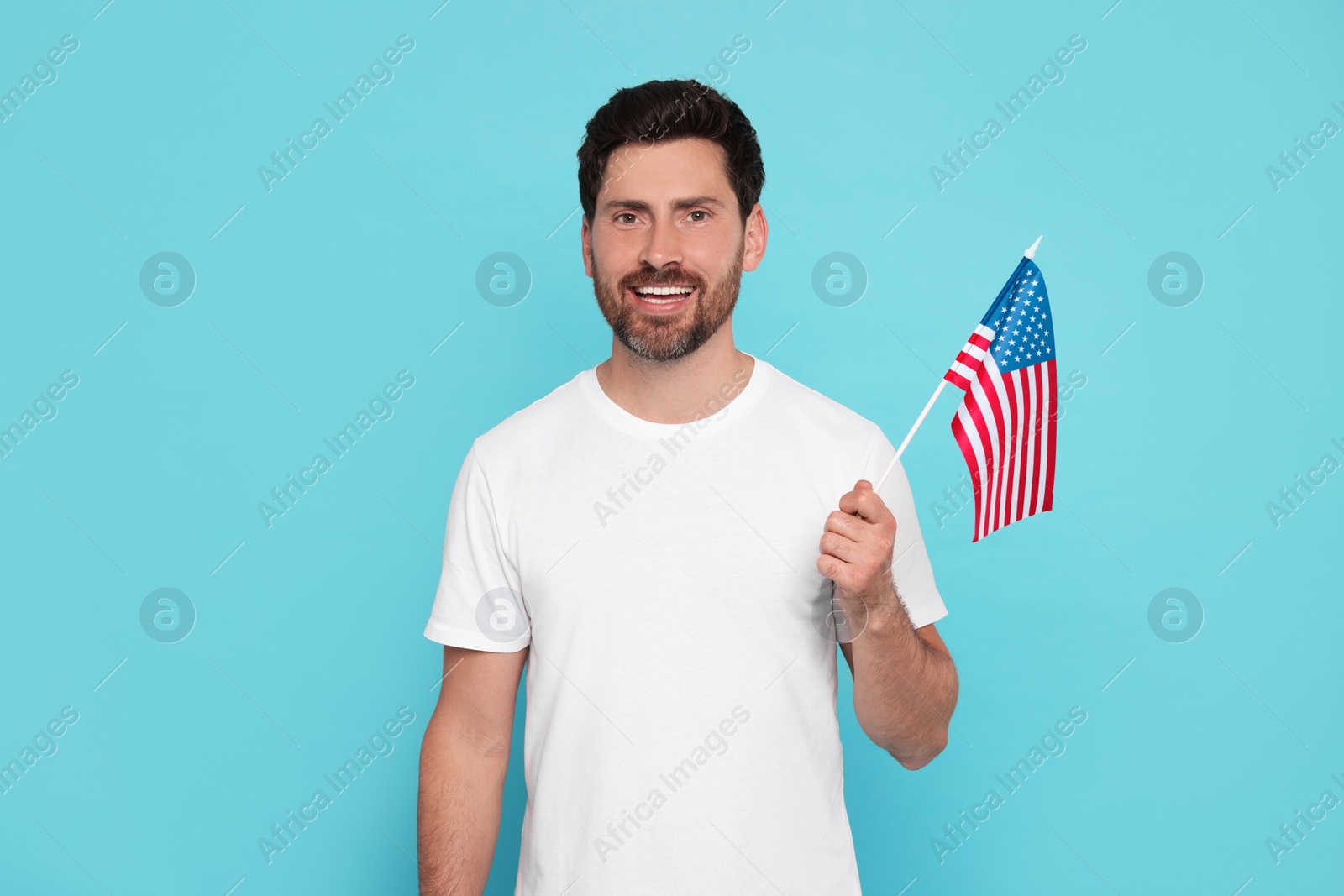 Photo of 4th of July - Independence Day of USA. Happy man with American flag on light blue background