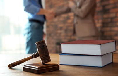 Photo of Judge's gavel and notary with client on background. Law and justice concept