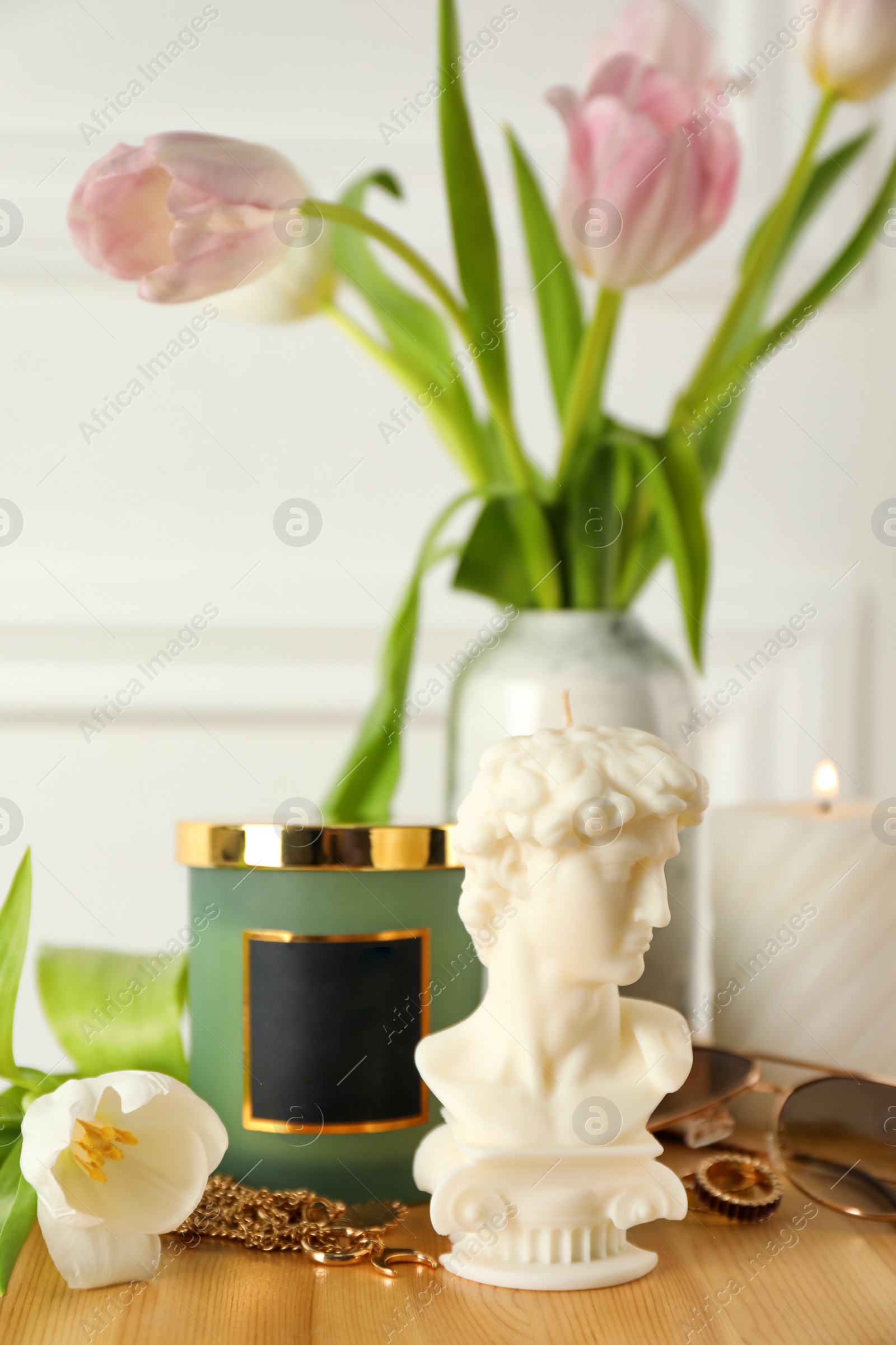 Photo of Beautiful David bust candle on wooden table. Stylish decor