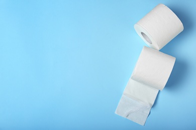 Rolls of toilet paper on color background, top view. Space for text