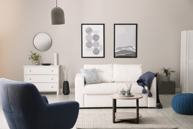 Stylish living room interior with white sofa, armchair and small coffee table