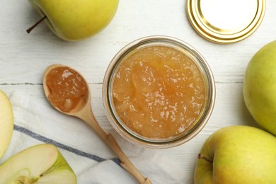 Photo of Homemade delicious apple jam on white wooden table, flat lay