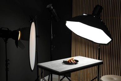 Photo of Composition with baked chicken, parsnip and strawberries on grey table in professional photo studio. Food photography