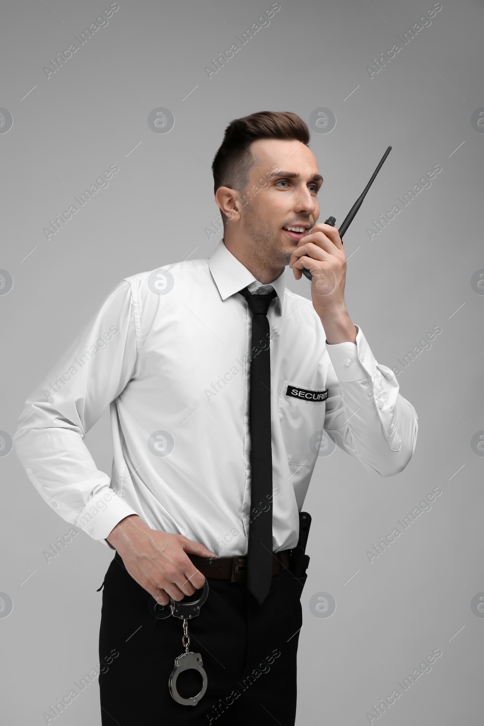 Photo of Male security guard using portable radio transmitter on color background