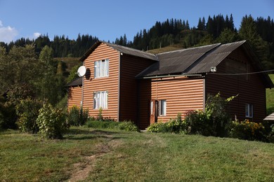 Modern house near forest on sunny day