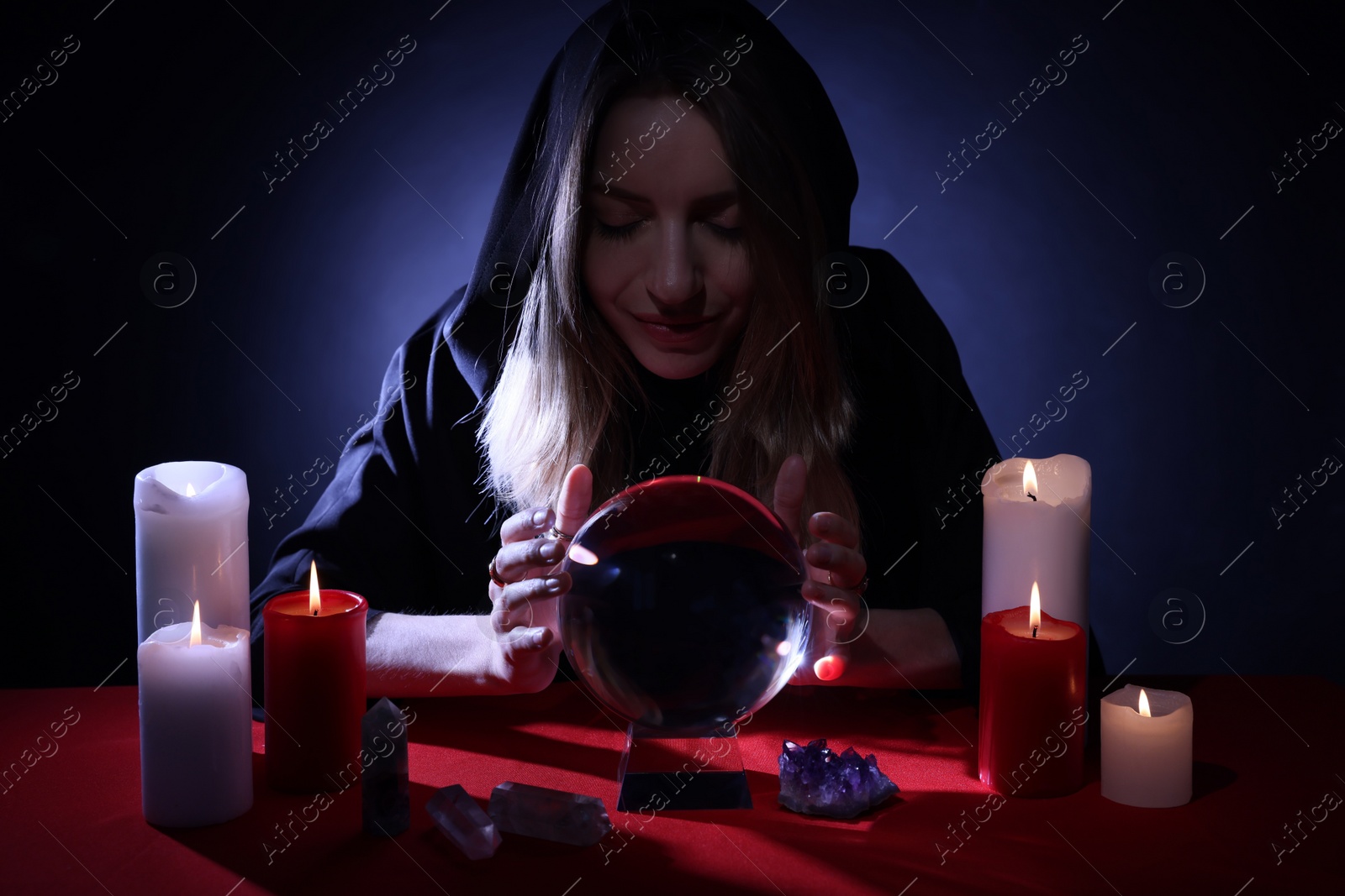 Photo of Soothsayer using crystal ball to predict future at table in darkness. Fortune telling