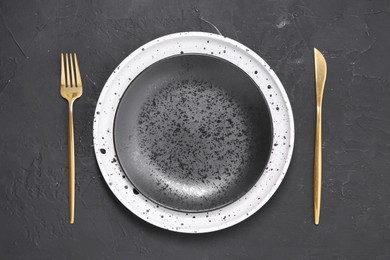 Photo of Elegant setting with shiny cutlery on black table, top view
