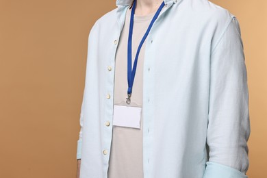 Photo of Man with empty badge on beige background, closeup