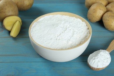 Photo of Starch and fresh potatoes on turquoise wooden table