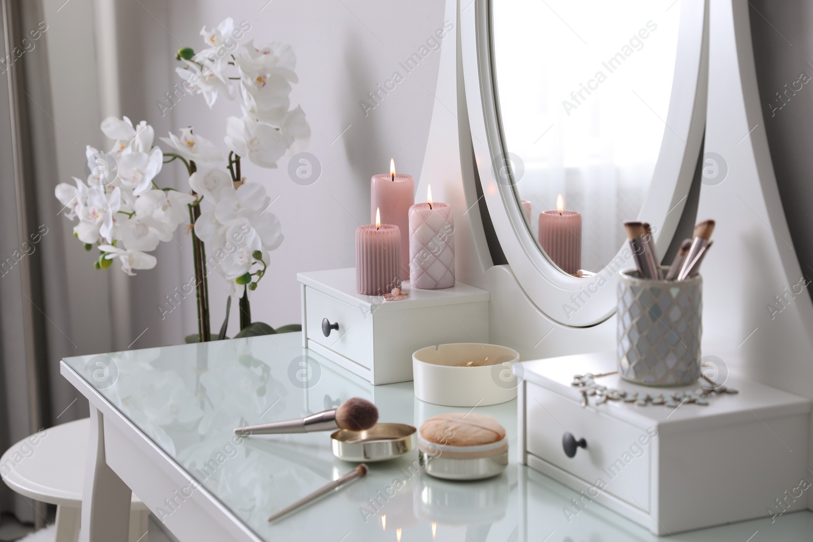 Photo of Wooden dressing table with decorative elements and makeup products in room