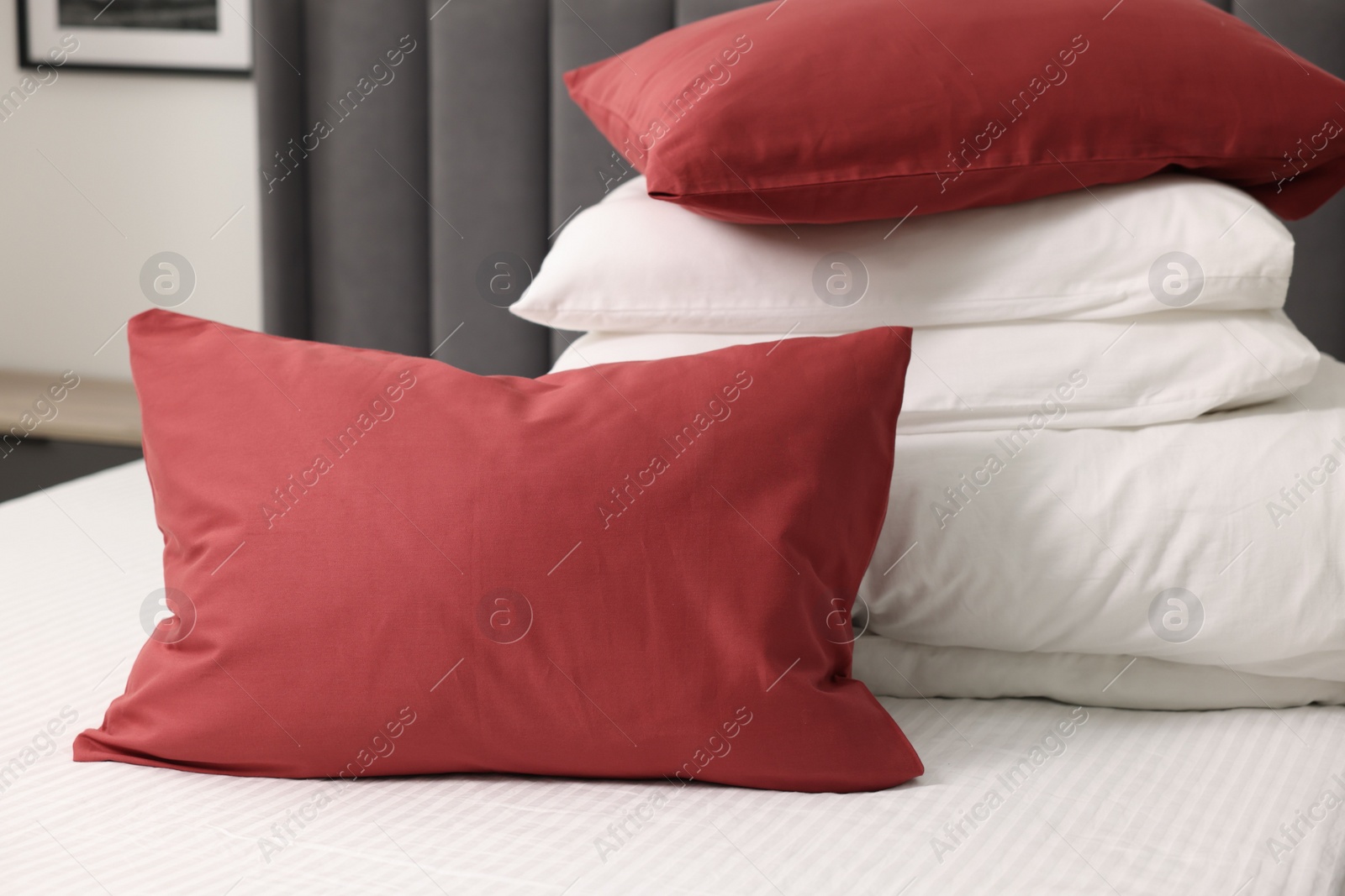 Photo of Soft pillows and duvet on bed at home