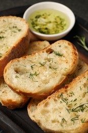 Photo of Tasty baguette with garlic and dill served on table, closeup