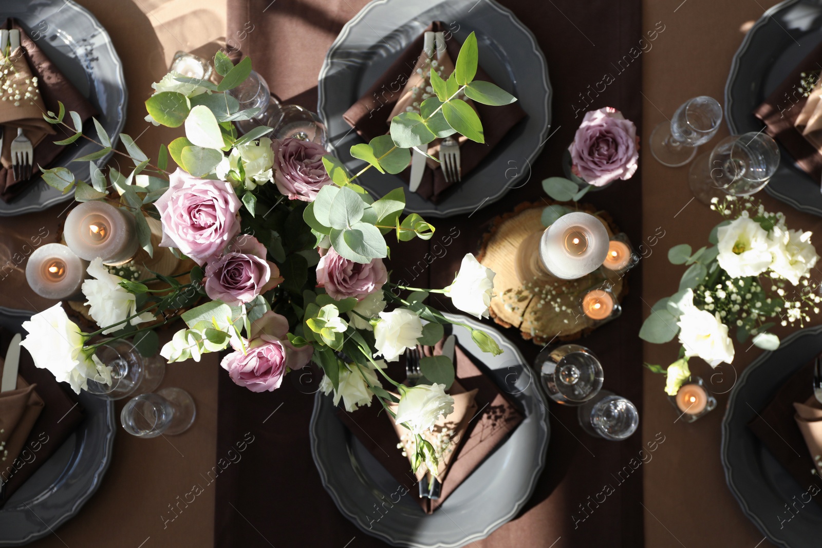 Photo of Festive table setting with beautiful tableware, candles and floral decor indoors, top view