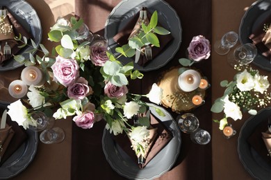 Festive table setting with beautiful tableware, candles and floral decor indoors, top view