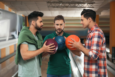 Group of men with balls in bowling club