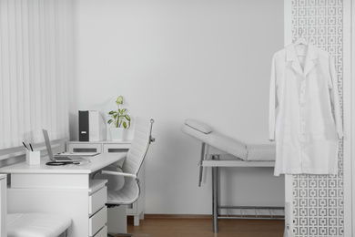 Photo of Doctor's office interior with desk and examination couch