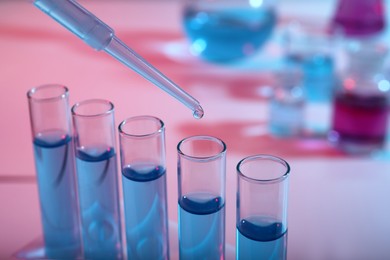 Photo of Dripping reagent into test tube with blue liquid, closeup. Laboratory analysis