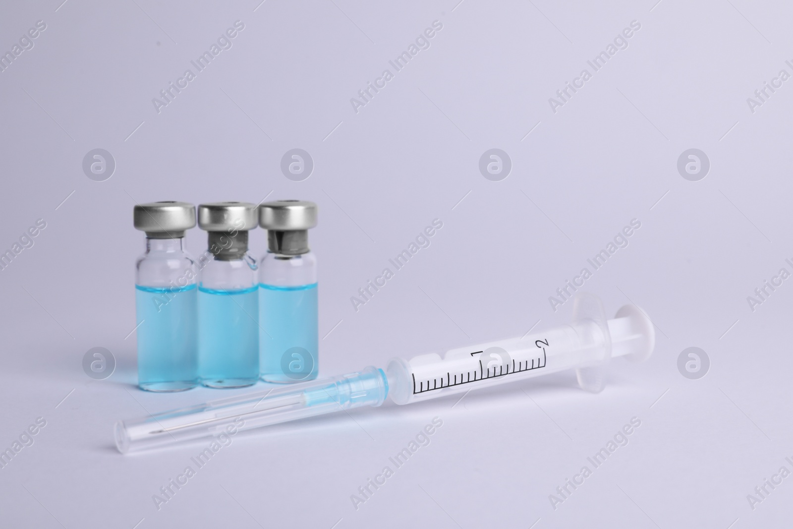 Photo of Disposable syringe with needle and vials on white background