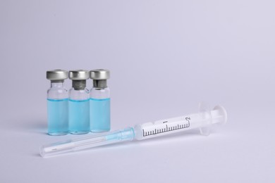 Photo of Disposable syringe with needle and vials on white background