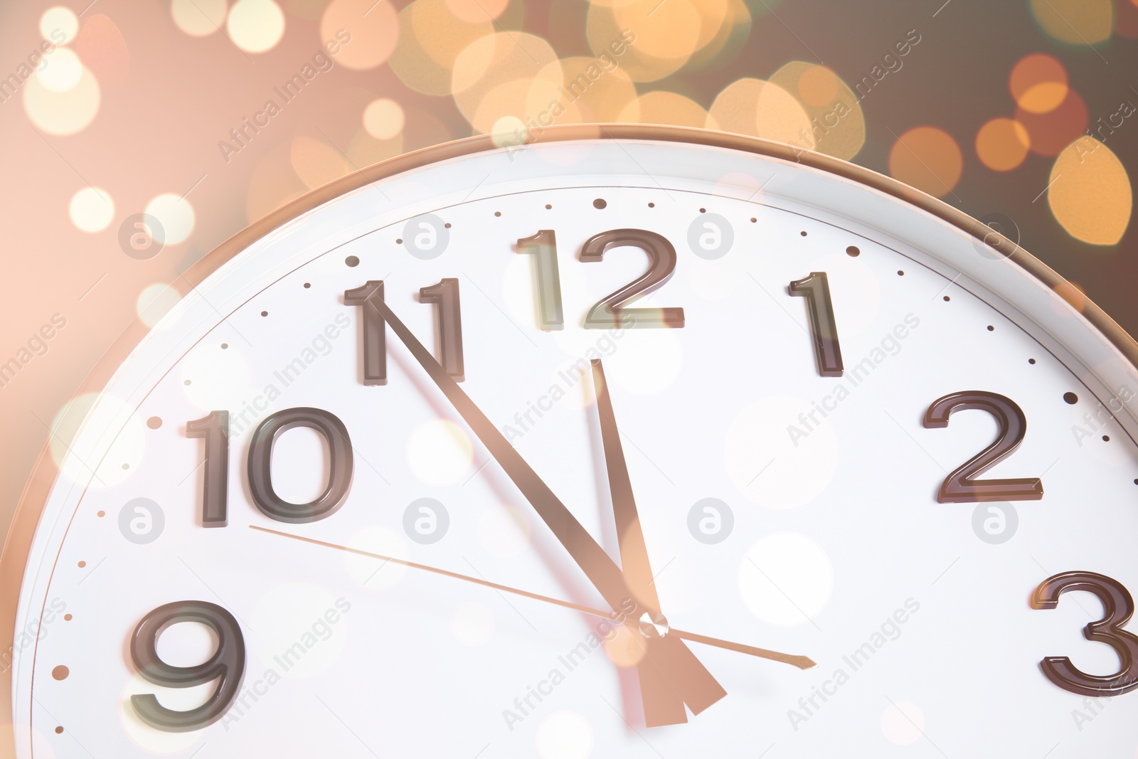 Image of Clock showing five minutes till midnight with bokeh effect, closeup. New Year countdown