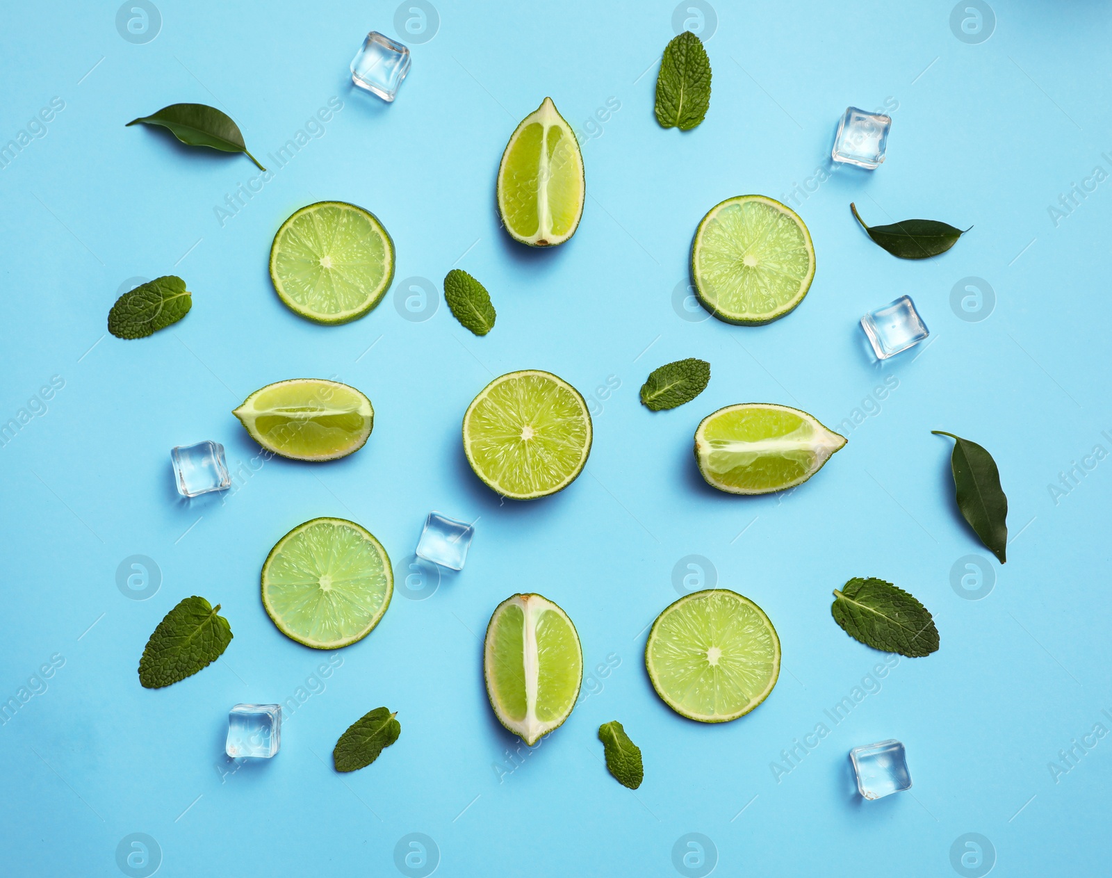 Photo of Flat lay composition with fresh juicy limes, mint and ice cubes on light blue background