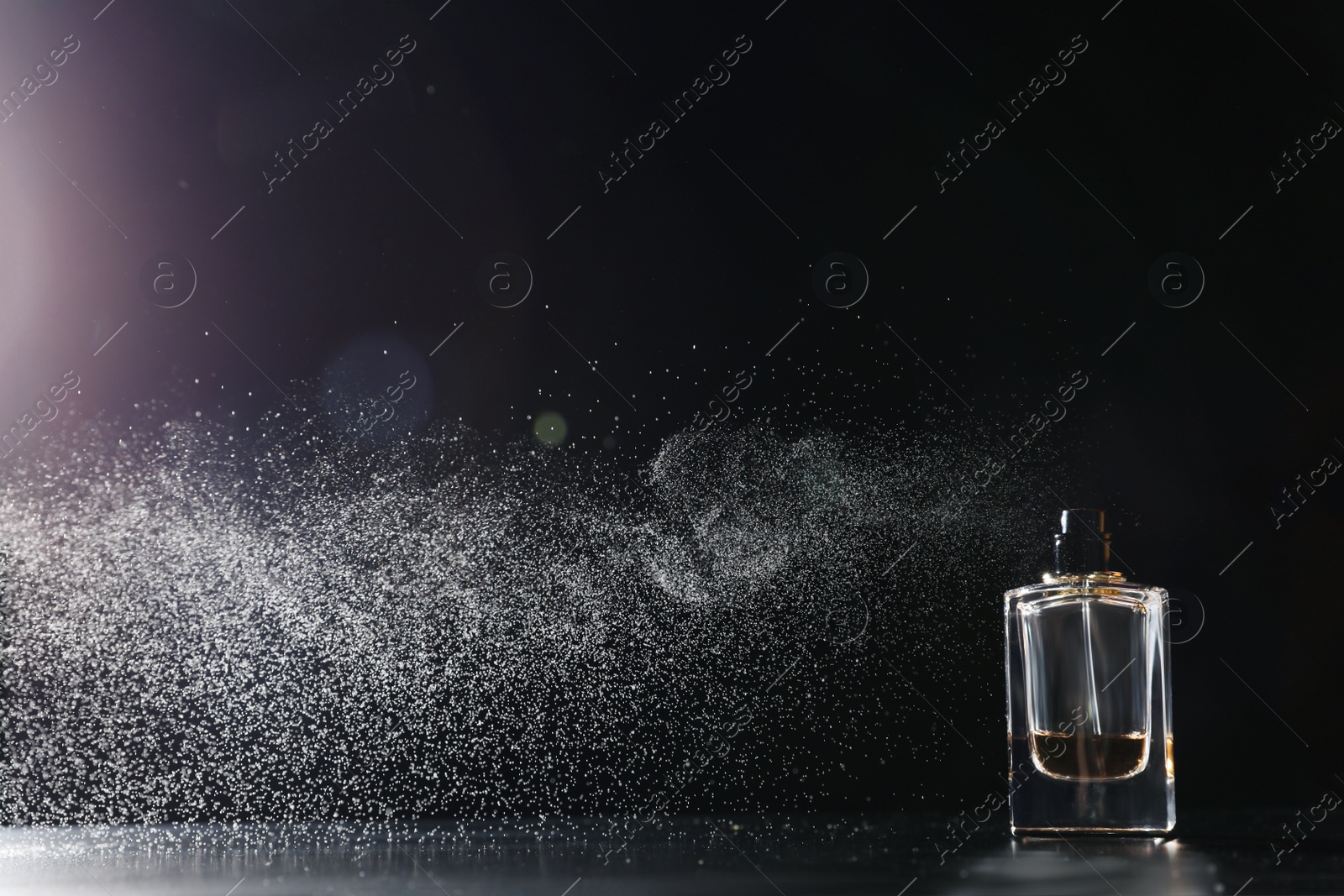 Photo of Woman spraying luxury perfume on black background, closeup