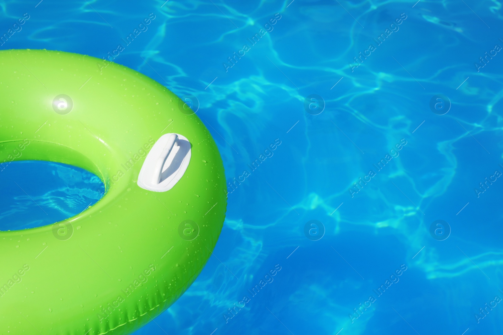 Photo of Inflatable ring floating in swimming pool on sunny day. Space for text