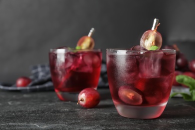 Photo of Delicious grape soda water on black table. Refreshing drink