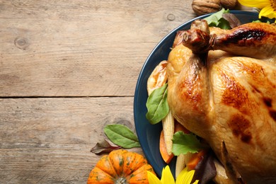 Traditional cooked turkey and autumn decor on wooden table, flat lay with space for text. Thanksgiving day celebration