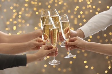 Photo of People clinking glasses of champagne on blurred background, closeup