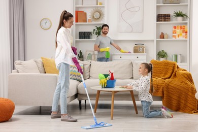 Photo of Spring cleaning. Happy family tidying up together at home