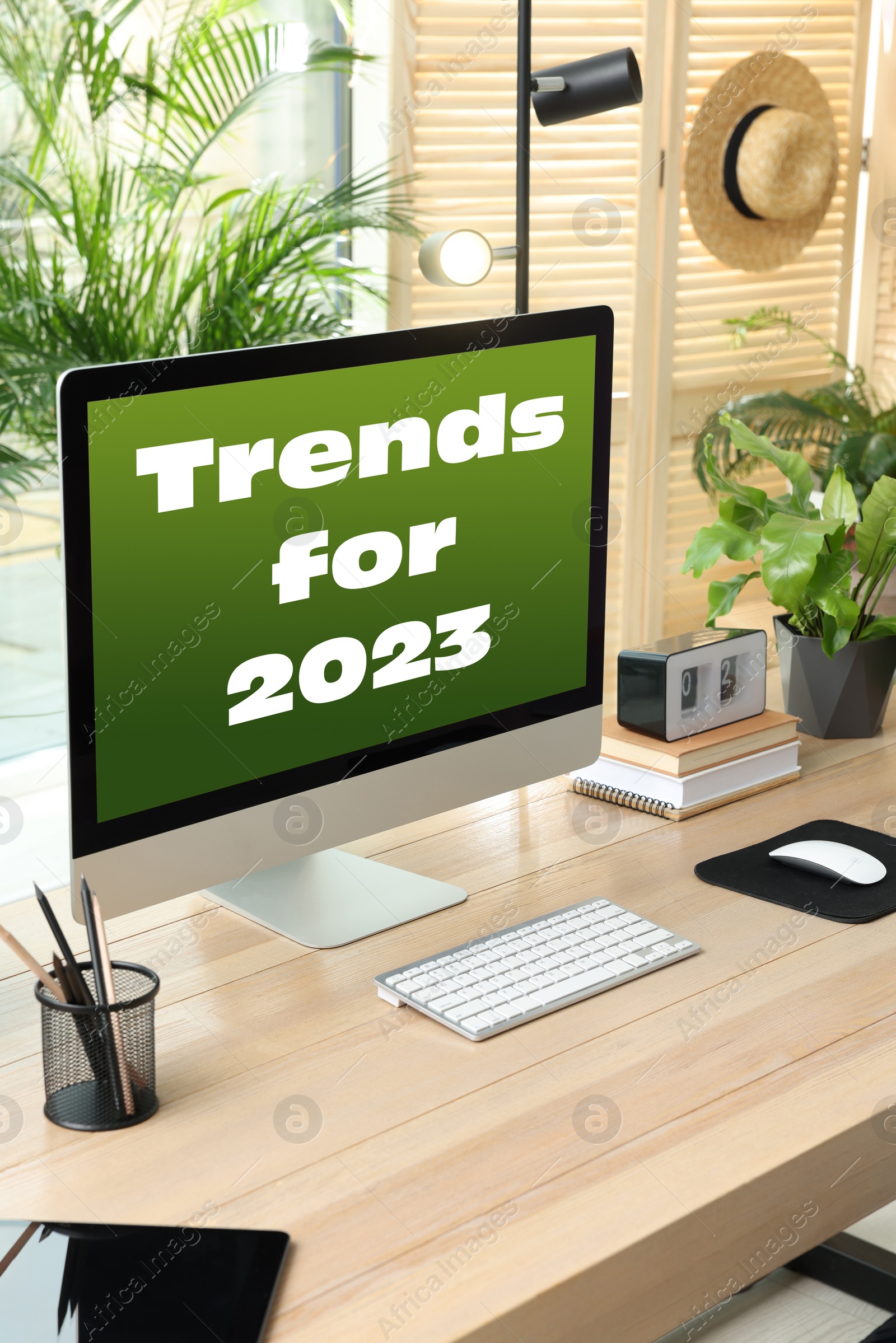 Image of Trends For 2023 text on computer monitor. Workplace with wooden table