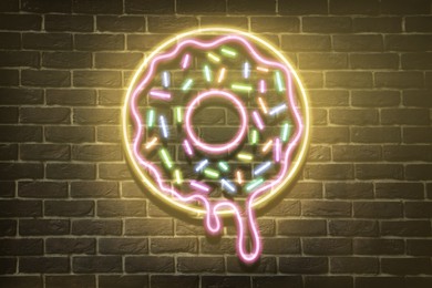 Doughnut glowing neon sign on brick wall