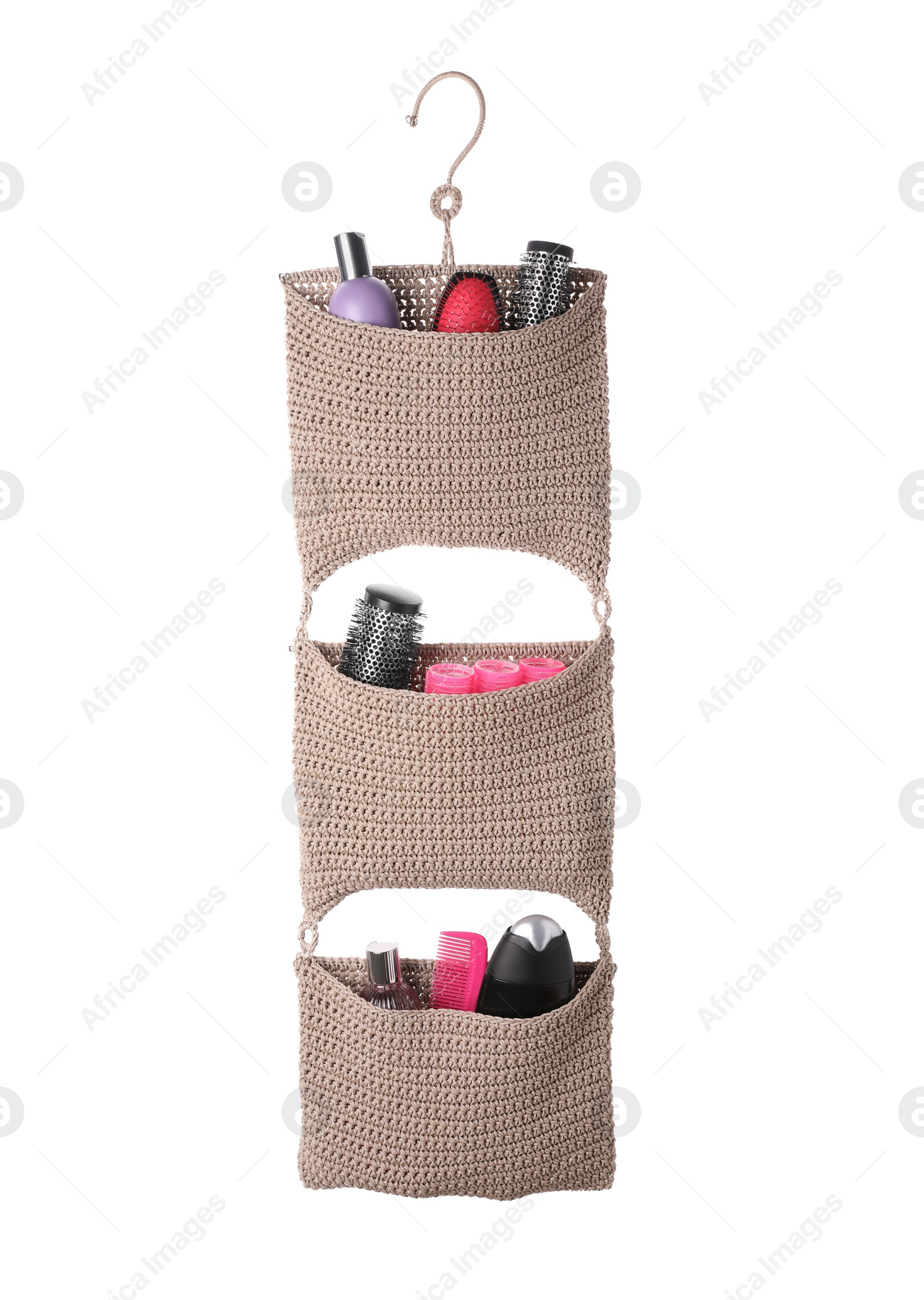 Photo of Stylish knitted organizer with toiletries and hair brushes on white background. Bath accessory