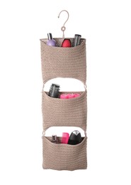 Photo of Stylish knitted organizer with toiletries and hair brushes on white background. Bath accessory