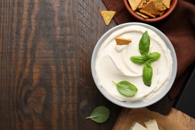 Delicious tofu sauce served with crunchy snack on wooden table, flat lay. Space for text