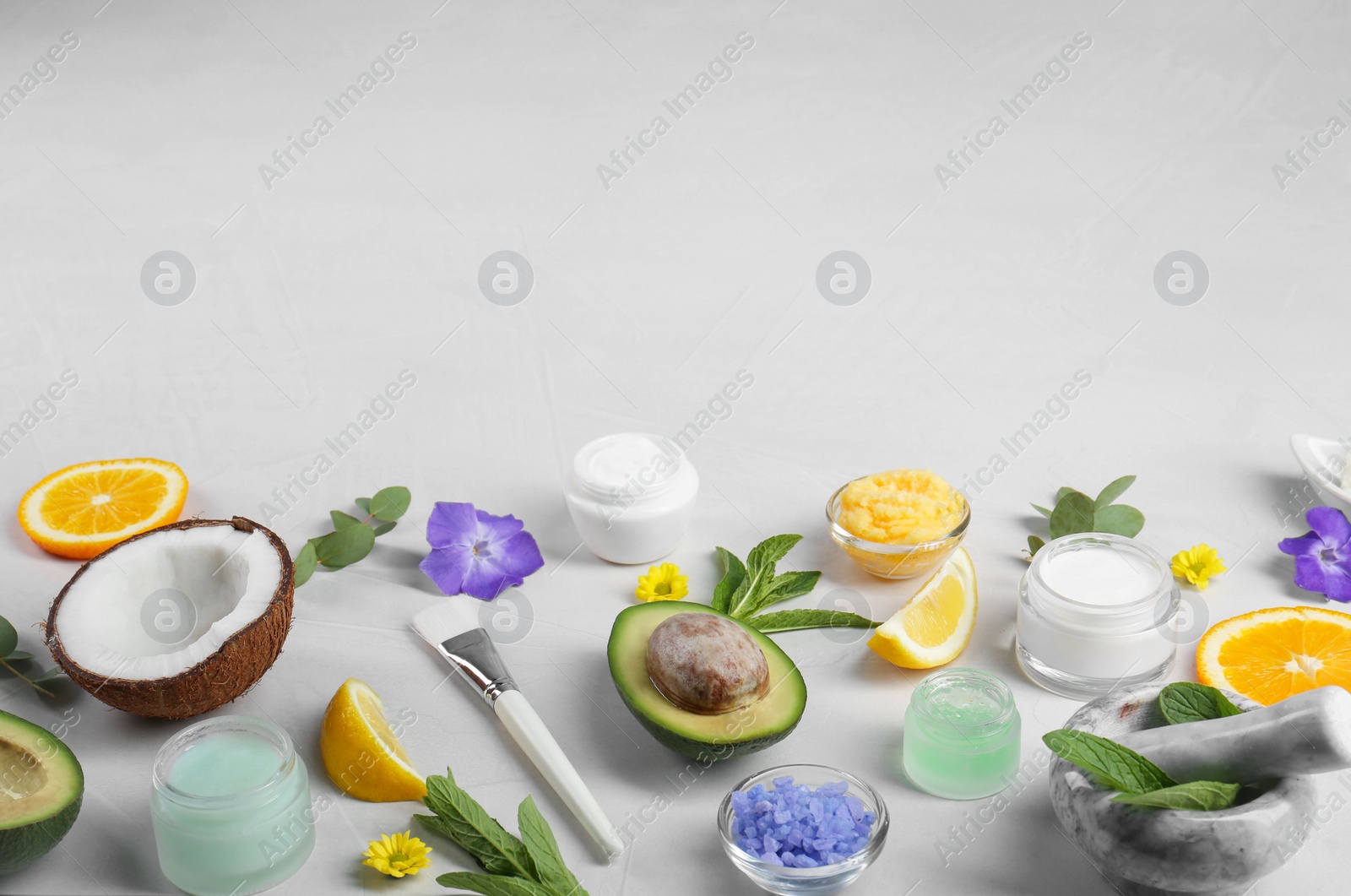 Photo of Homemade cosmetic products and fresh ingredients on light grey background. Space for text