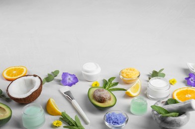 Homemade cosmetic products and fresh ingredients on light grey background. Space for text