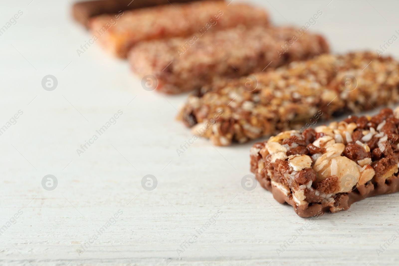 Photo of Tasty protein bars on white table. Space for text