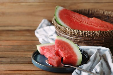 Photo of Fresh juicy watermelon and spoon on wooden table. Space for text